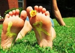 Pies sin hongo con una flor entre los dedos